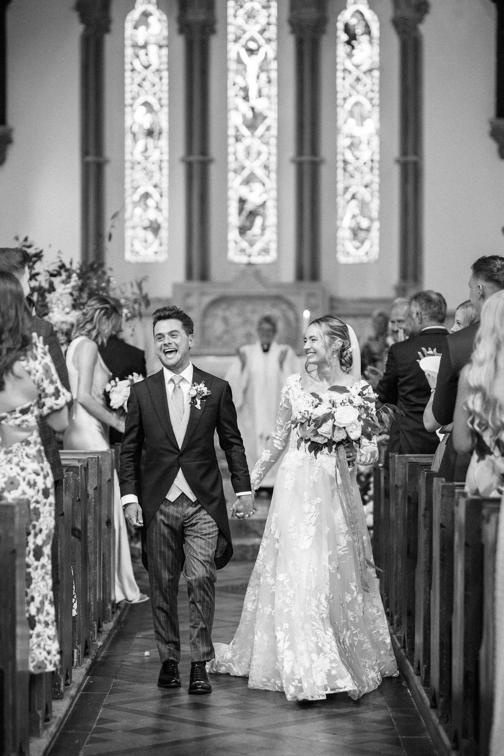 Bride and groom walking up aisle at church wedding