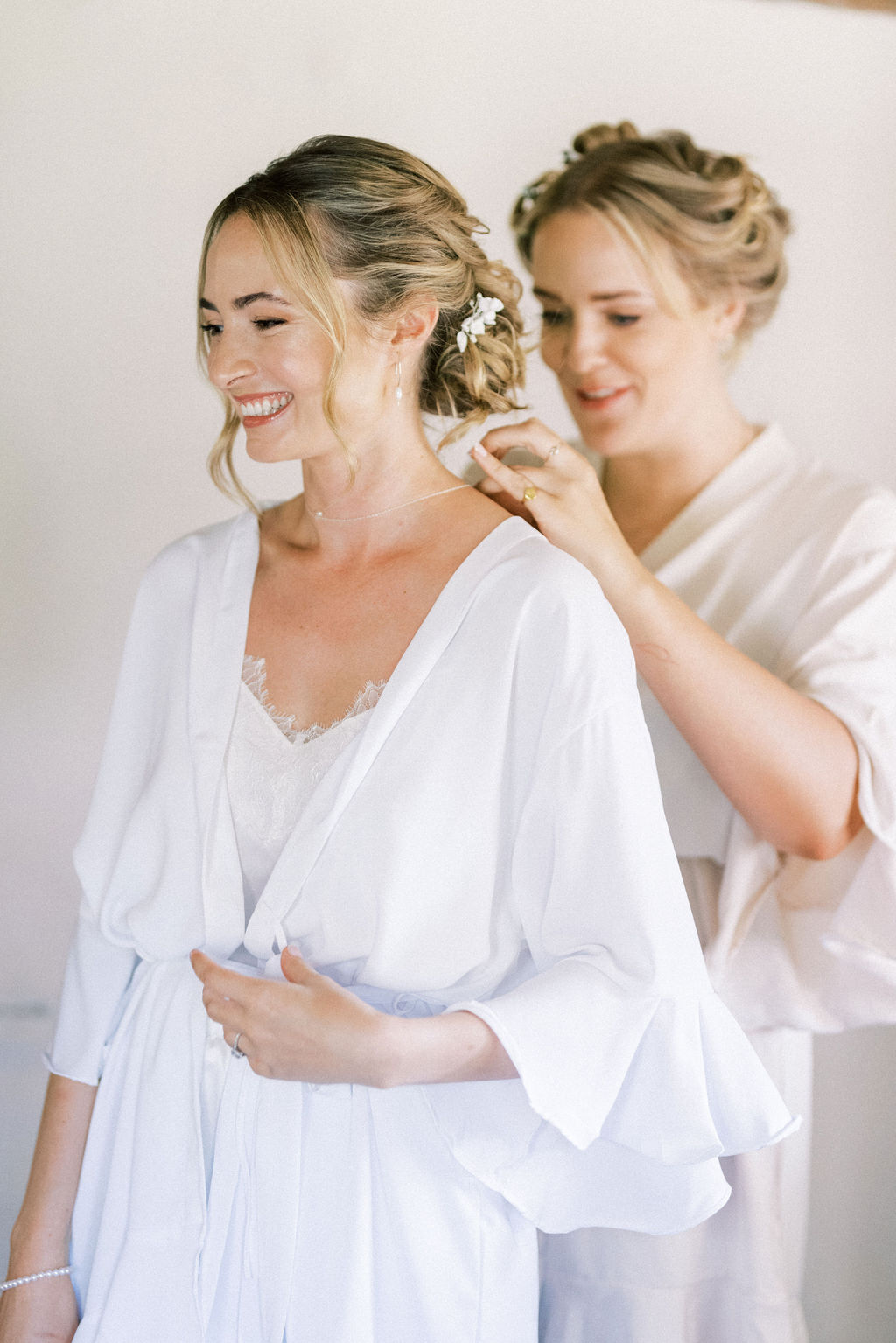 Bride on wedding morning putting on jewelery