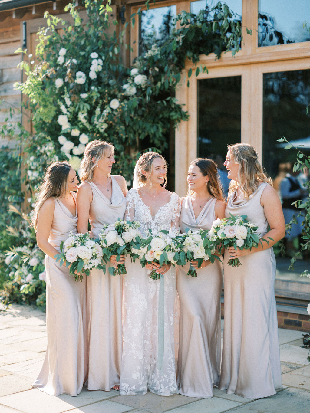 Bride and bridesmaids in blush pink at garden marquee wedding