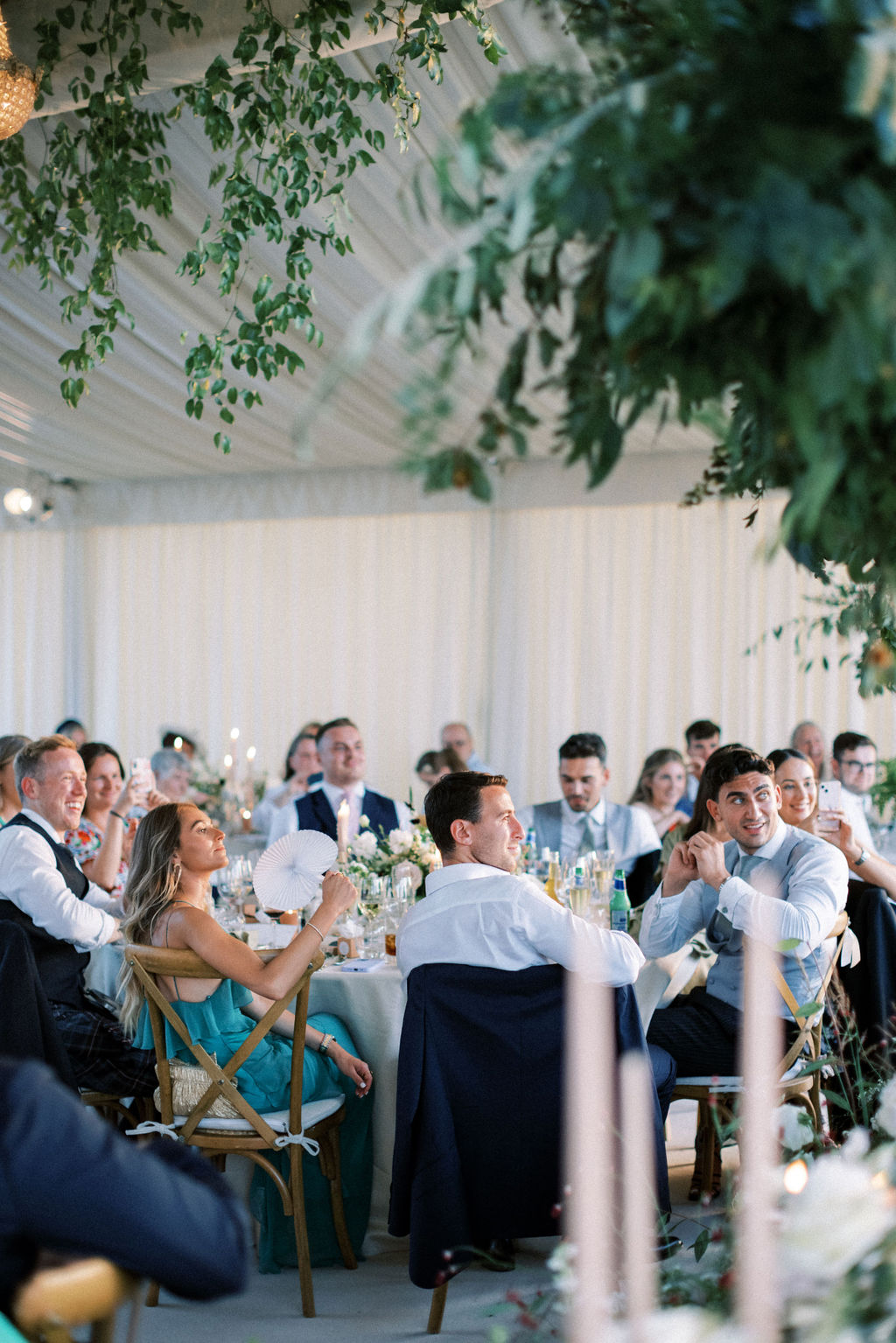 guests with white paper fans at wedding