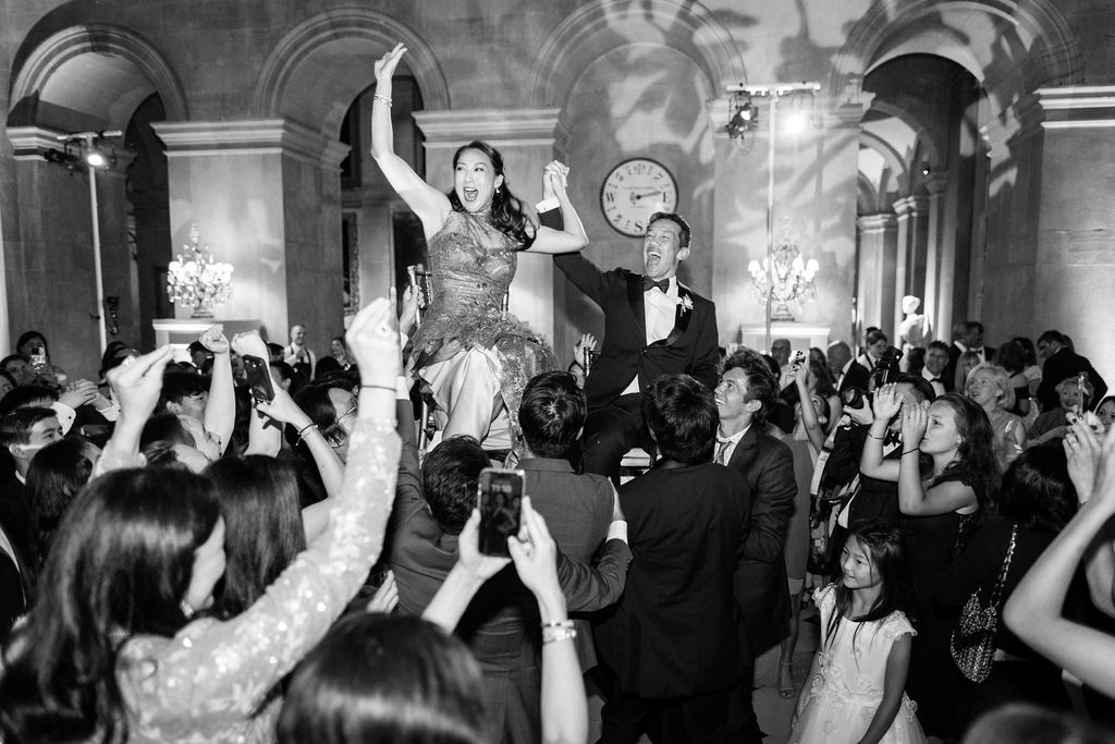 Bride and groom being lifted up on dance floor at Blenheim Palace wedding