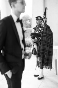 Guests arriving with bagpiper playing at Goodwood House Summer Wedding