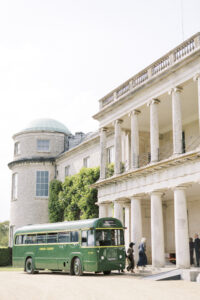 Guests arriving on vintage bus at Goodwood House Summer Wedding